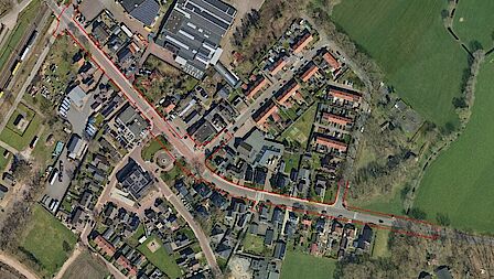 Luchtfoto van de Wolweg met daaromheen woningen, bedrijven, andere wegen en stukken grond.